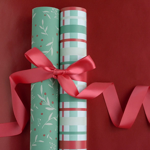 2 rolls of wrapping paper - one in a holly design and the other in a check design. Tied together with a red satin ribbon.